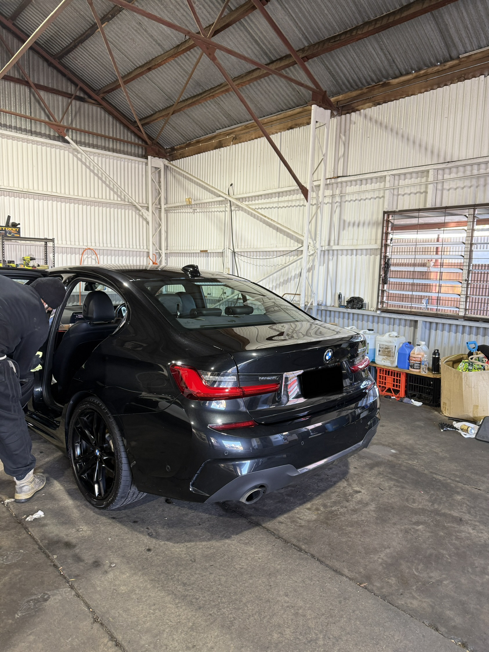 A car being detailed by hand inside the wash bay at Singh Hand Car Wash
